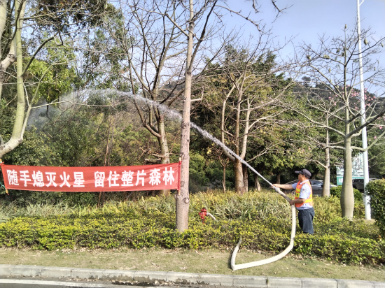 西門保安對停車場周邊進(jìn)行灑水降燥.jpg