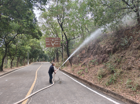 山頂保安對山頂山路邊進(jìn)行灑水降燥.jpg
